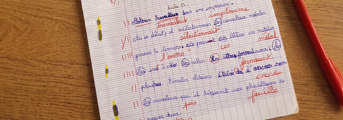 Cahier de dictée annoté de nombreuses corrections en rouge